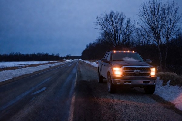 A canvas tool roll and recovery gear laid out on a truck tailgate