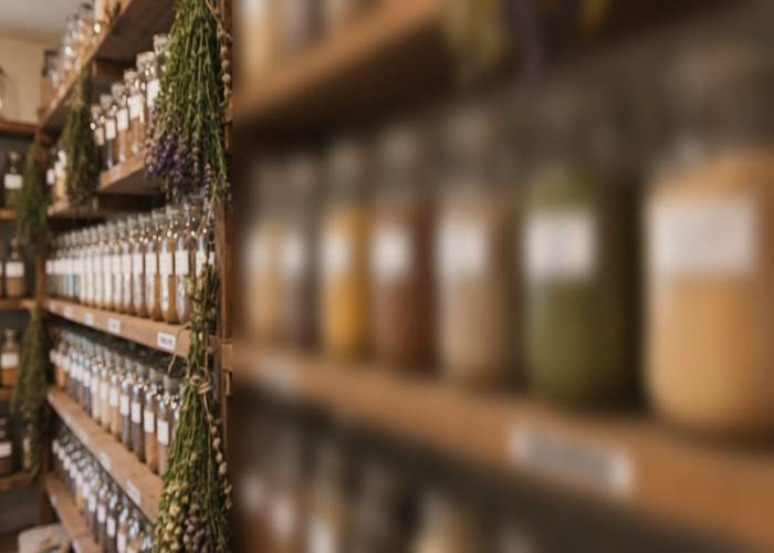 Rows of glass jars filled with dried seeds on wooden pantry shelves